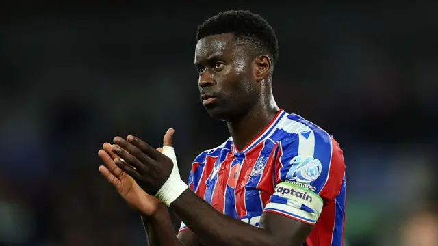 Marc Guehi applauding towards fans after a Crystal Palace game