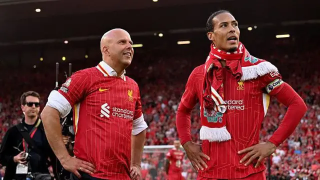 Arne Slot looks on with Virgil van Dijk after winning Premier League title
