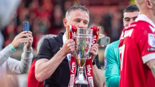 Wrexham manager Phil Parkinson kisses the League One trophy