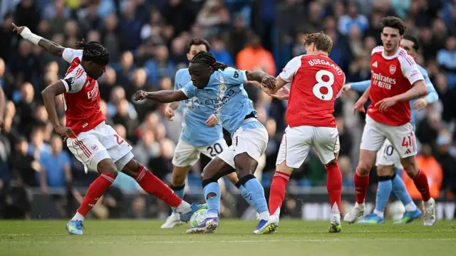 Jeremy Doku battling for possession with Arsenal's Noni Madueke