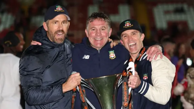 Wrexham boss Phil Parkinson (centre) with the club's owners Ryan Reynolds (left) and Rob McElhenney (right) after promotion from the National League