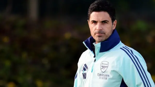 Mikel Arteta walks onto the training pitch at Arsenal