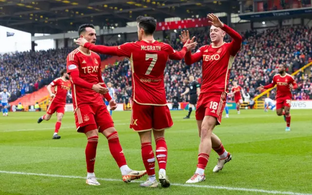 Aberdeen's Jamie McGrath (C) celebrates scoring to make it 1-0 with teammates (L-R) Bojan Miovski and Killian Phillips during a Scottish Cup Quarter Final match between Aberdeen and Kilmarnock at Pittodrie Stadium, on March 09, 2024, in Aberdeen, Scotland. 