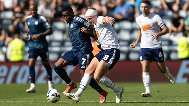 Leicester City's Abdul Fatawu and Preston's Ali McCann in a battle for the ball on the pitch at Deepdale Stadium.