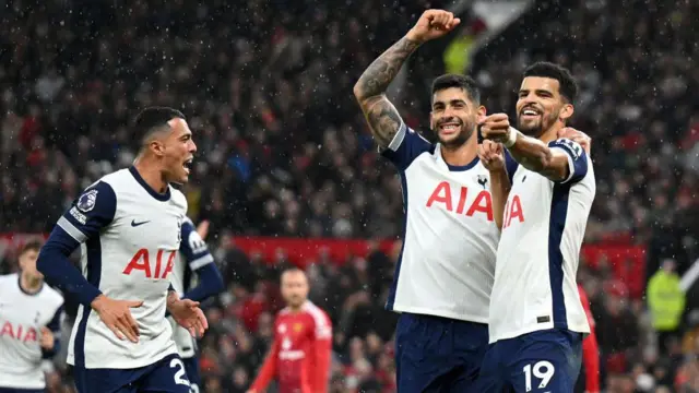 Dominic Solanke of Tottenham Hotspur celebrates scoring his team's third goal with teammate Cristian Romero during the Premier League match between Manchester United FC and Tottenham Hotspur FC at Old Trafford on September 29, 2024