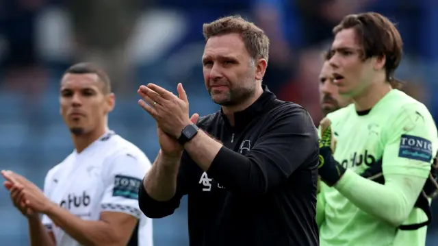 Derby head coach John Eustace claps the Rams fans after their draw with Portsmouth