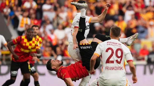 Goztepe's Romulo attempts an overhead kick as two defenders try to challenge him