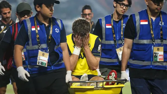 Ole Romeny being stretchered off the field of play with his head in his hands