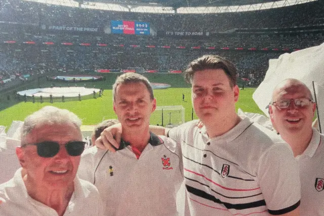A dad, grandad and uncle posing at a Fulham game.