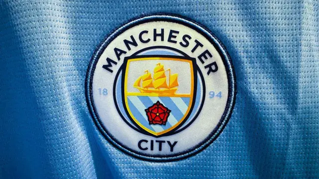The Manchester City logo is seen on a football jersey