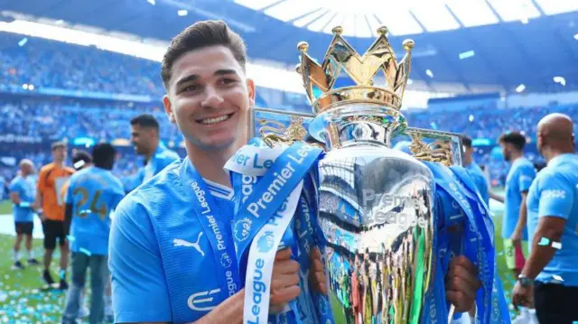 Julian Alvarez holds the Premier League trophy