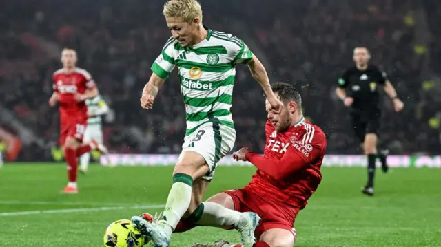 Nicky Devlin of Aberdeen tackles Celtic's Daizen Maeda