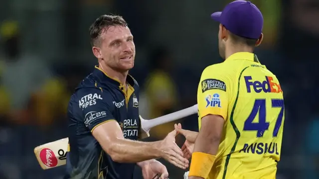 Gujarat Titans' Jos Buttler shakes hands with Chennai Super Kings' Anshul Kamboj after the match