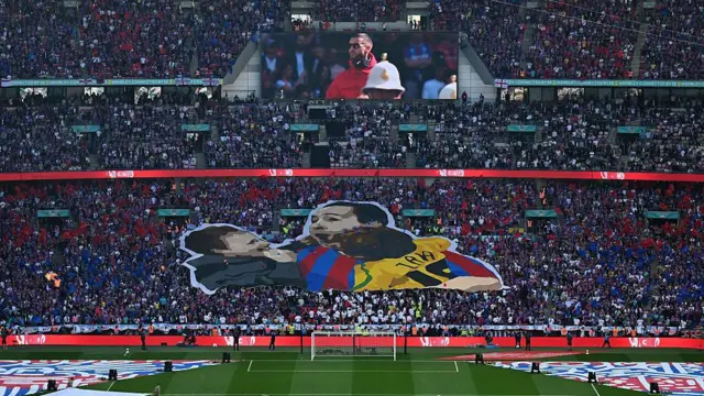 A tifo in the Crystal Palace end at Wembley displaying a man celebrating with his two sons