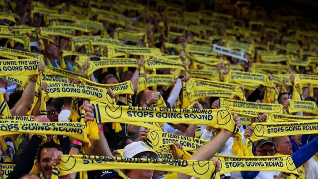  Fans of Leeds United hold up scarves