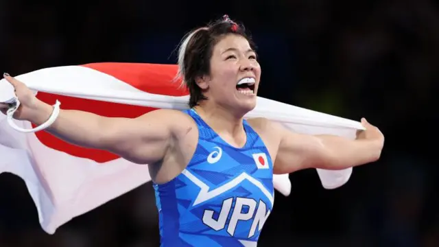 Yuka Kagami celebrates after winning freestyle wrestling gold at the Paris Olympics