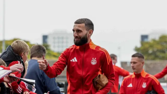 ABERDEEN, SCOTLAND - SEPTEMBER 21: Aberdeen's Graeme Shinnie signs autographs during a Premier Sports Cup quarter-final match between Aberdeen and The Spartans at Pittodrie, on September 21, 2024, in Aberdeen, Scotland. (Photo by Craig Foy / SNS Group)