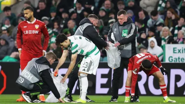 Celtic's Sebastian Tounekti clears balls from the pitch following a Celtic fan Protest during a UEFA Europa League Play-Off First Leg match between Celtic and VFB Stuttgart at Celtic Park
