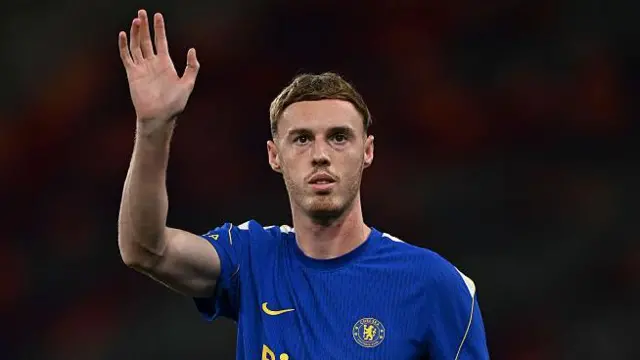Cole Palmer waves on the pitch at the Kai Tak Stadium