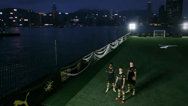 An aerial shot of Phil Foden, Abdukodir Khusanov and Ryan McAidoo modelling Manchester City's new away kit