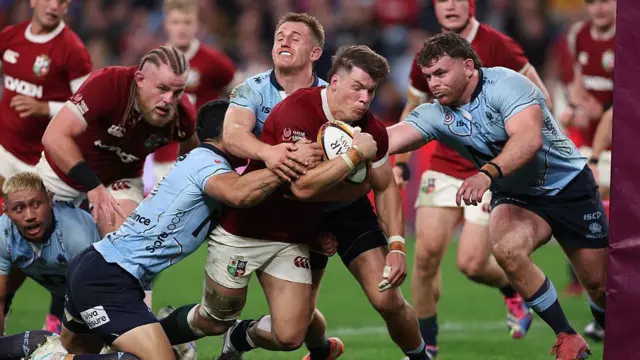 Huw Jones trundles past Waratahs defenders to score his second try of the game