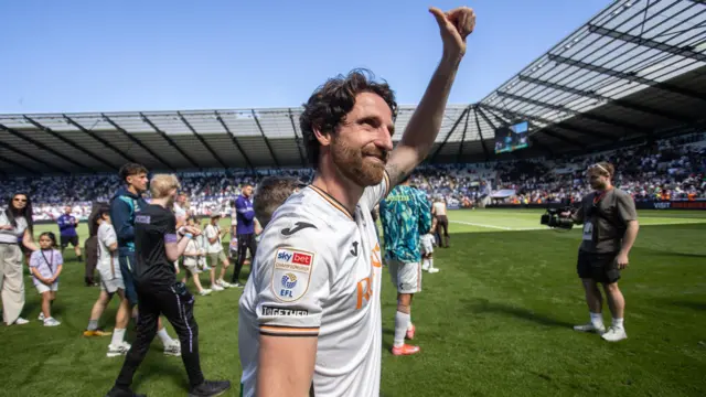 Joe Allen gives a thumbs up to fans as he walks off the pitch after playing for Swansea