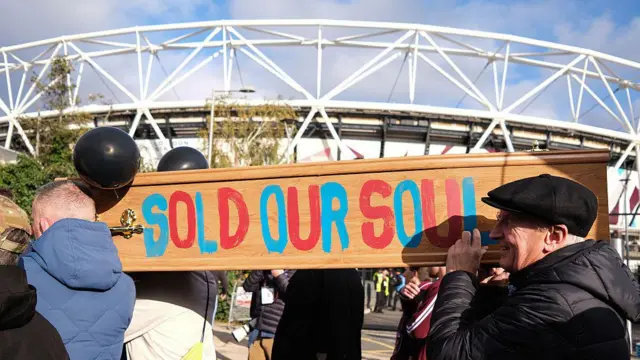 West Ham fans carry a coffin in protest against the clubs owners - words on coffin read 'Sold Our Soul'
