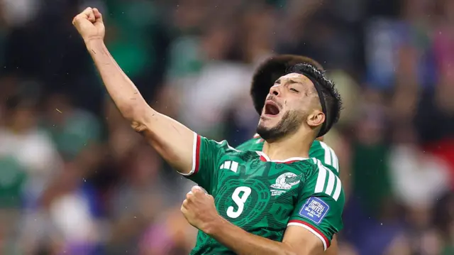 Raul Jimenez, wearing his green Mexico kit, celebrates scoring his goal against Ecuador on Wednesday with his fist in the air