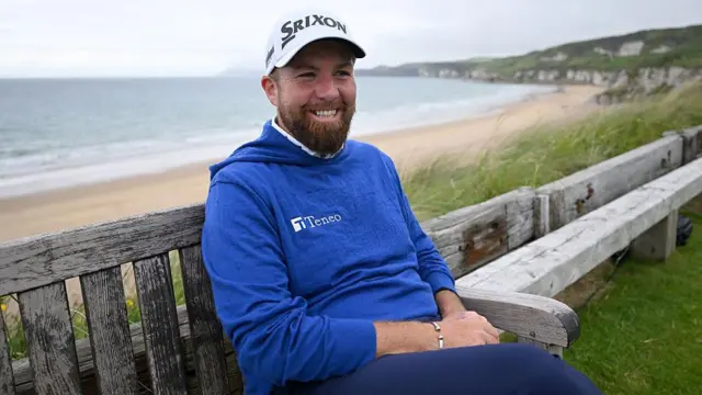 Shane Lowry smiling while sat on the bench at the 16th hole at Royal Portrush.