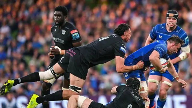 Jack Conan of Leinster is tackled by JP du Preez, left, and Euan Ferrie of Glasgow Warriors during the United Rugby Championship match between Leinster and Glasgow Warriors at the Aviva Stadium in Dublin