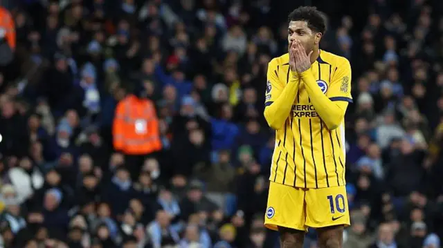 Georginio Rutter holds his face with his hands in disappointment during Brighton's game at Manchester City