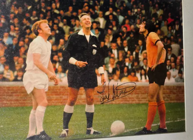 A photo of Leeds United's Billy Bremner and Wolves' Frank Munro at a coin toss, signed by Munro