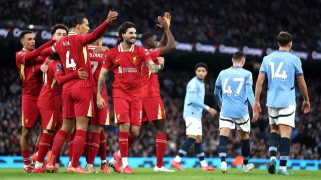 Liverpool players celebrate in front of dejected Man City players