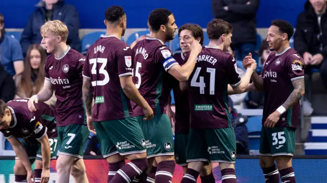 Swansea players celebrate at QPR in midweek 