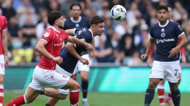 Wrexham's Liberato Cacace battles for the ball with Millwall's Camiel Neghli