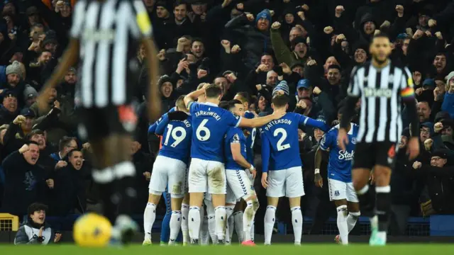 Everton's English midfielder #07 Dwight McNeil is mobbed by team-mates 