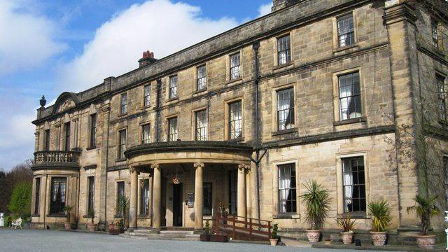 The front of Beamish Hall hotel. The stone building has three storeys and columns in front of its entrance.