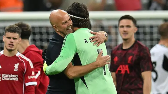 Liverpool manager Arne Slot embraces goalkeeper Alisson after victory against Newcastle