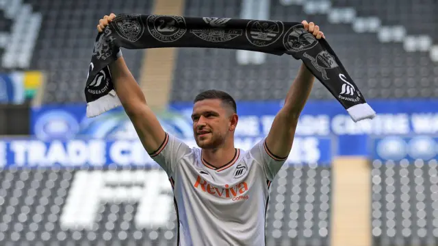 Zan Vipotnik holds up a Swansea scarf