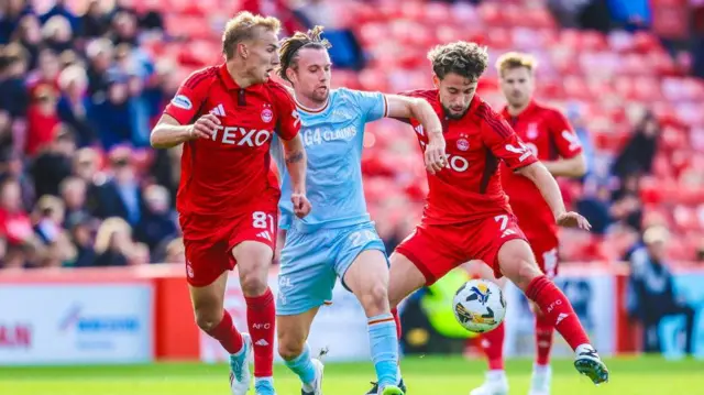 Aberdeen's Topi Keskinen (L) and Adil Aouchiche (R) and Motherwell's Lukas Fadinger
