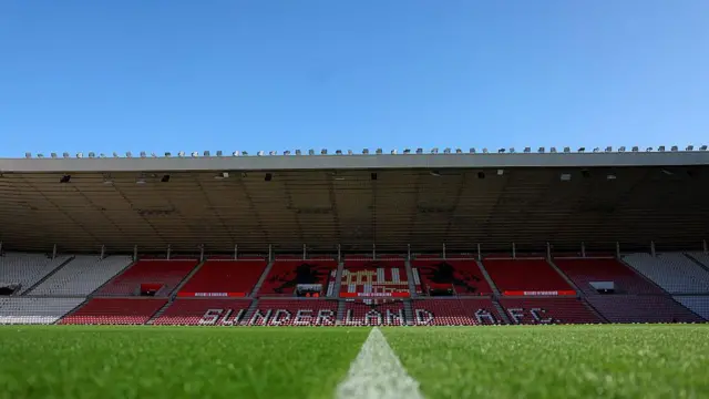 An empty stand at the Stadium of Light from very low down at pitch level with blue sky in the background