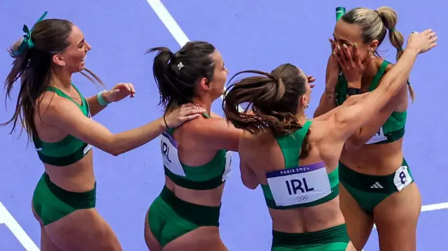 Kelly McGrory, Phil Healy and Sophie Becker are about to embrace Sharlene Mawdsley after her stunning anchor leg in the Olympic women's 4x400m heats