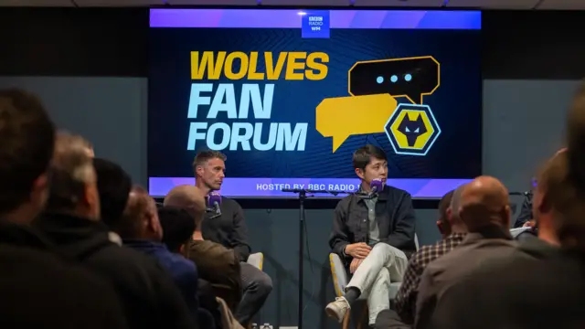 Nathan Shi sat next to Wolves manager Rob Edwards