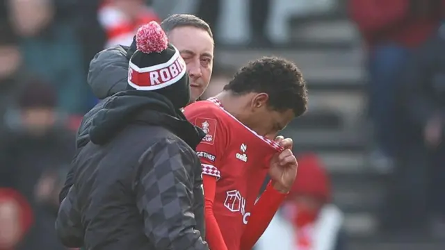 Bristol City midfielder Marcus McGuane leaves the field after sustaining a head injury