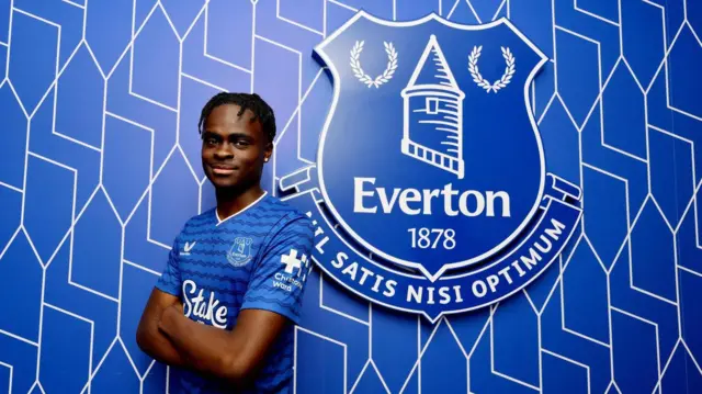 Tyrique George poses for photos in an Everton kit after signing