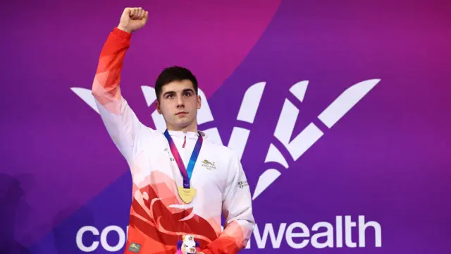 Will Ellard puts his fist up in the air as he collects his gold medal for the men's 200m freestyle S14 in Glasgow