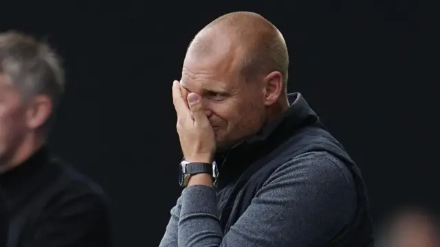 Liam Manning covers his face