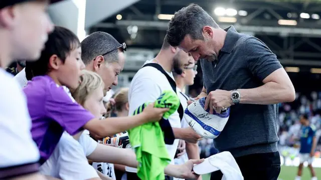 Marco Silva signing autographs on the touchline