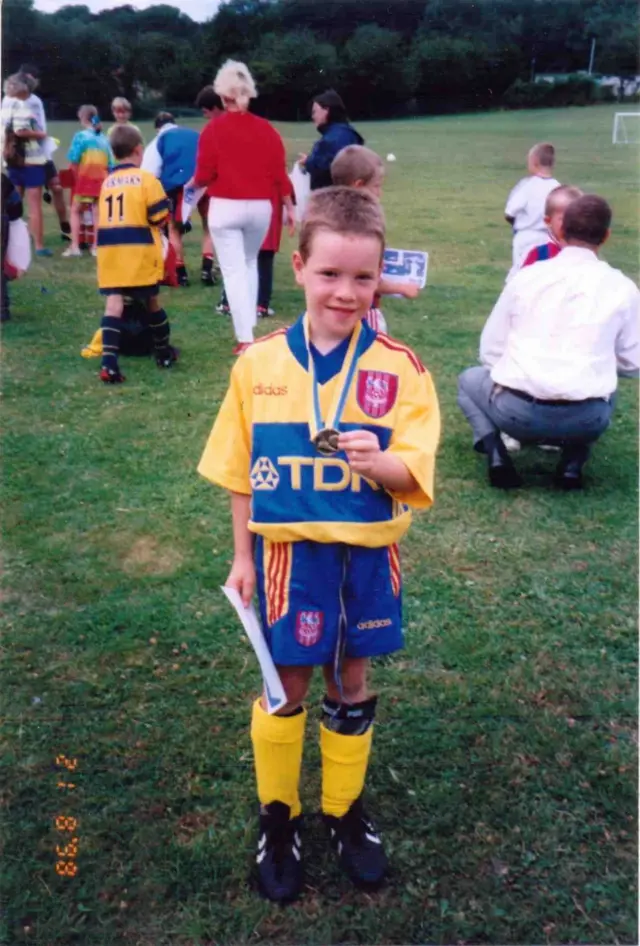 Boy in a Crystal Palace kit poses with a medal