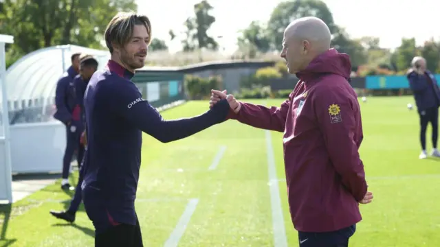 Jack Grealish and Lee Carsley shake hands in training 